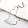 Macro detail of silver adjustable slider bracelet with oval white stone and box chain - White