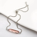 Macro shot of silver box chain bracelet with pink oval crystal and adjustable toggle - Pink