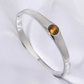 Polished silver stainless steel bangle with a round tiger eye stone inlay for women - Steel