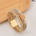 Makroaufnahme eines mehrlagigen Wickelarmbands mit Kristallen und Magnetverschluss - Khaki