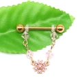 Detailed macro view of golden stainless steel barbell piercing with pink crystal flower chain - Pink