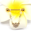 Detail of gold flower nipple ring with chain and sparkling crystals on a flower - White