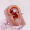 Detailed view of an industrial barbell featuring a pink heart opal with wings and diamonds - Heart Pendant Industrial Barbell