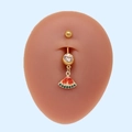 Primer plano de piercing de ombligo de sandía con circonitas rojas y verdes en metal dorado - Sandía Dorada