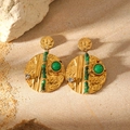 Detail of bohemian gold earrings with hammered texture and green stone on natural rock - Hammered Round Green Gemstone Earrings (LC40046)