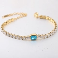 Macro-opname van gouden tennisarmband met blauwe rechthoekige steen en witte zirkonia - Goudblauw