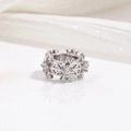 Macro shot of silver snowflake ring featuring clear cubic zirconia insets on white silk - Zirconia Snowflake Bead / White Gold