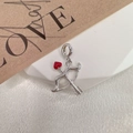 Macro detail of silver Cupid bow pendant with a vibrant red heart-shaped arrow tip - Style H