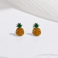Détail de boucles d'oreilles ananas jaunes en émail vert sur un support miroir blanc - Ananas Jaune