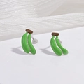 Détails de boucles d'oreilles bananes miniatures en émail posées sur un ruban de soie blanc - Banane Verte