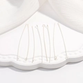 Dettaglio macro di spilli a T in argento S925 su piatto di ceramica per gioielli DIY - Chiodino ad Occhiello Argento