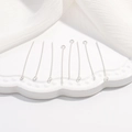 Primo piano di chiodini ad occhiello in argento S925 per gioielli su piatto bianco - 20mm*0.5mm (1g) / Chiodino ad Occhiello Platino