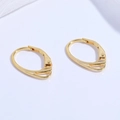 Détail de boucles d'oreilles dormeuses dorées avec motif triangle ajouré sur fond blanc - Or