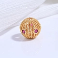 Macro shot of gold-plated S925 silver hollow bead with intricate red gemstone inlay - Gold Rose Zircon Hollow Twisted Round Bead