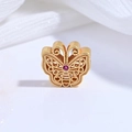 Macro shot of gold-plated butterfly bead with filigree details and a red gemstone - Gold Rose Zircon Hollow Butterfly Bead