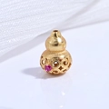 Macro detail of a hollow gold-plated s925 gourd bead with pink gemstone and floral carving - Gold Rose Zircon Hollow Gourd Bead