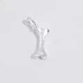 Macro detail of a bone-shaped S925 silver pendant with a polished shiny metallic finish - Bone / Silver