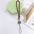 Detail of a brown braided leather phone strap with a crystal flower metal pendant charm - Woven Rope Small Flower Brown (K6156)