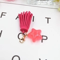 Detail of hot pink star charm and suede tassel accessory with golden lobster clasp - Rose Red