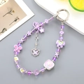 Detailansicht der lila Perlen-Handykette mit Schmetterling- und Blumenanhängern - Lila