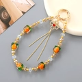 Handmade beaded phone strap featuring orange persimmon glass charms and golden tassels - Orange Persimmon Clover Tassel (K4935)