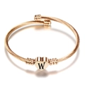 Detail van roségouden kabelarmband met hartvormige hanger en een zwart gegraveerde letter W - Initiaal W