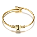 Macro-detail van de 18K gouden kabelarmband met een gegraveerde harthanger en letter J - Letter J