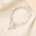 Close-up of beaded bracelet with moonstone beads and silver lucky charm pendants - Green (K3400)