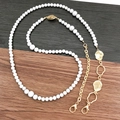 Dettaglio catena di perle fai-da-te con inserti dorati e chiusure a moschettone - Oro