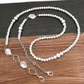 Dettaglio della lunga catena di perle con accenti in metallo organico argentato - Argento