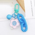 Dettaglio del fermaglio a ferro di cavallo verde menta con campanello blu e fiore rosa - Catena Blu Lago Fiore