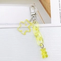 Detail view of yellow acrylic bear keychain with translucent links and resin charms - Yellow