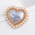 Macro detail of heart-shaped iridescent gem charm with white pearl border and gold base - Iridescent Purple (D1236)