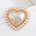 Macro detail of a heart-shaped pearl charm with iridescent resin and golden base - Iridescent Light Yellow (D1233)