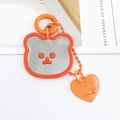 Détail du porte-clés miroir ours orange vif avec pendentif cœur gravé au logo - Breloques / Orange
