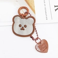 Détail du porte-clés miroir en acrylique en forme d'ours avec breloque cœur gravée - Breloques / Marron