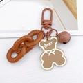Close-up of brown acrylic bear keychain with matching small bell and plastic chain - Coffee Bear Pendant
