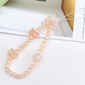 Detailed view of peach pink beaded phone strap with pearlescent bow and matte round beads - Phone Chain / Orange (K1685)