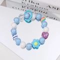 Detailed macro shot of beaded bracelet with pearl blue beads and heart-shaped pendant - Blue Flower