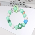 Detail of sweet beaded phone strap with mint green pearls and blue heart flower charms - Green Flower Green Beads
