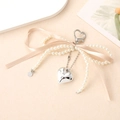 Elegante llavero de lazo con perlas con colgante de corazón y cinta en tono crema - Champán