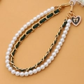 Detail of pearl lanyard with green woven chain and black heart charm with golden bow - Green