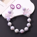 Dettaglio del laccetto per cellulare con perle viola marmorizzate e fiocchi a farfalla - Stile Fiocco con Perline Bicolore Viola