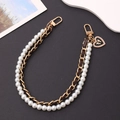 Detail of leather chain and pearl strap with heart charm and bow for phone or bag - Coffee