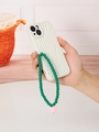 White textured phone case with green beaded strap and pink heart charm in hand - Pink Heart Pendant Style (K551)