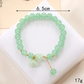 Light green beaded crystal bracelet with lily of the valley pendant and gold spacers - Green Jade Glass Lily Valley (K3630)