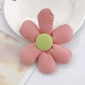 Detailed view of a handmade pink fabric sunflower accessory on a white plate - Pink