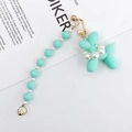 Close-up of mint green matte balloon dog charm with white pearls and gold hardware - Green