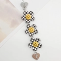 Nahaufnahme der Schachbrett-Blumenkette mit gelben Smileys und Herzanhängern aus Metall - Schachbrett Blumen Stil (K732)