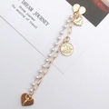 Dettaglio del bracciale a doppio strato dorato con perle, ciondoli a cuore e medaglietta - K2401 / Catena Perle Artificiali Doppio Strato Con Pendente (Chiusura Cuore)